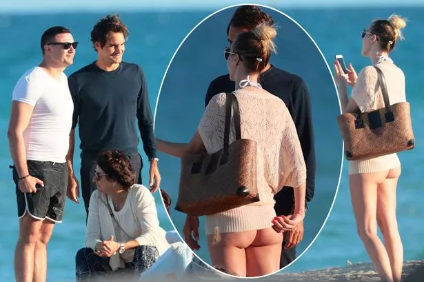 Roger Federer upstaged by female fan as she flashes BARE BOTTOM while posing with star