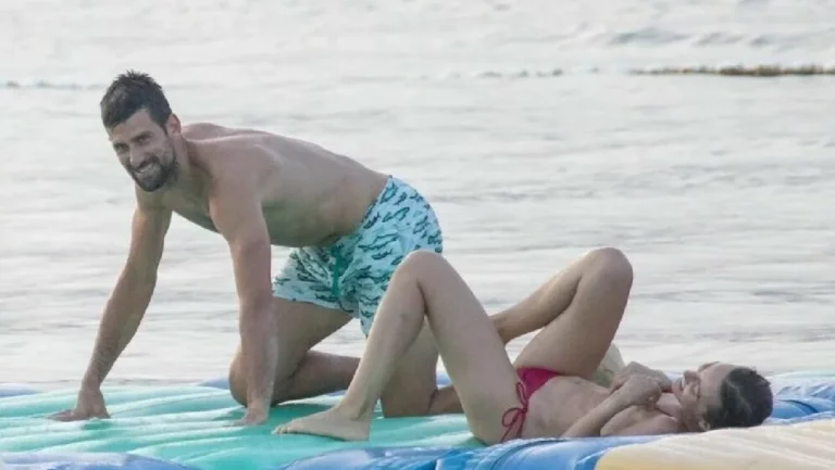 Novak Djokovic and wife Jelena share a kiss before they crash to the ground while taking on aqua